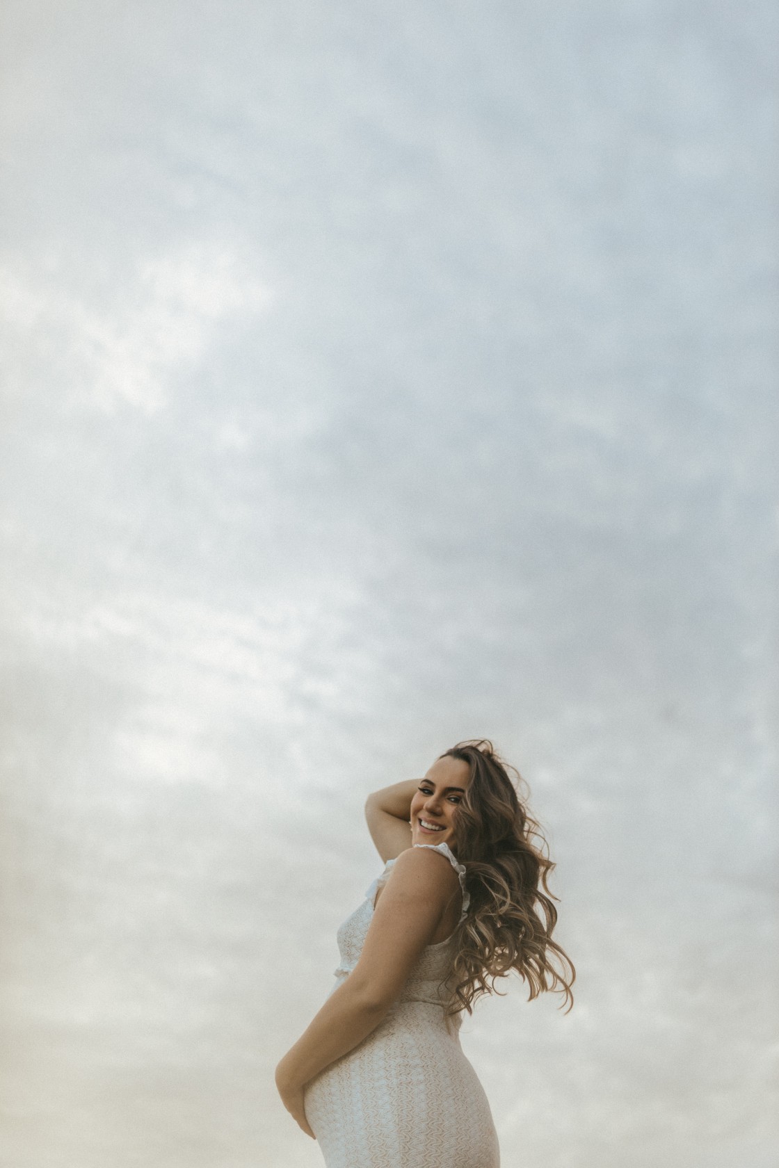 Gestante fotografada com o céu ao fundo
